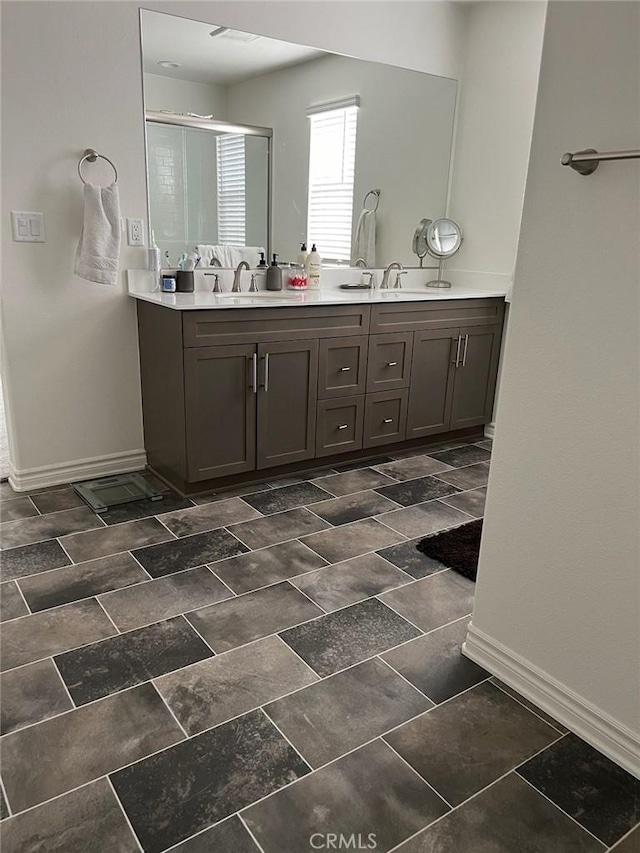 bathroom featuring a shower with shower door and vanity