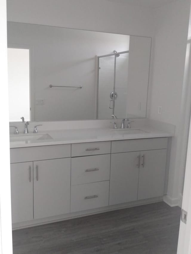 bathroom featuring hardwood / wood-style floors, an enclosed shower, and vanity