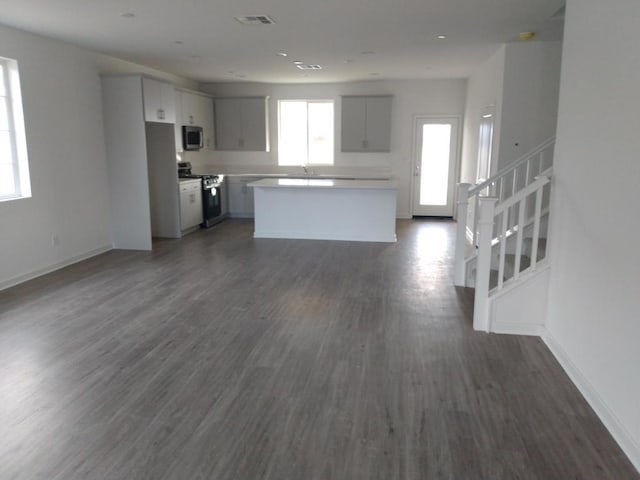 kitchen featuring dark hardwood / wood-style floors, a kitchen island, sink, stainless steel appliances, and white cabinets