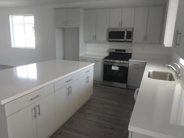 kitchen featuring dark wood-type flooring, sink, white cabinetry, and appliances with stainless steel finishes