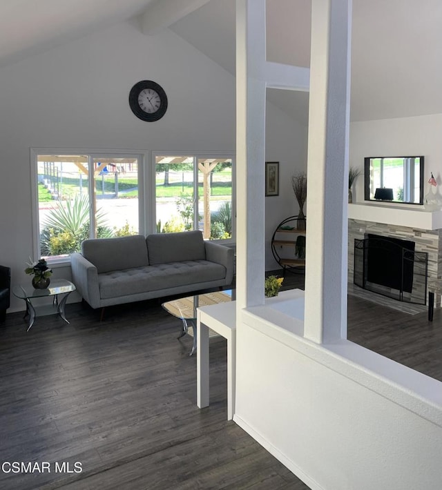 living room featuring high vaulted ceiling, dark hardwood / wood-style floors, beamed ceiling, and a stone fireplace