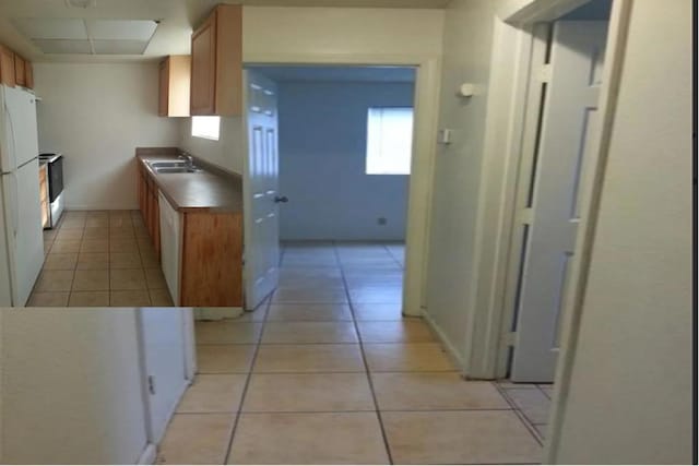 kitchen with light tile patterned floors, sink, and white appliances