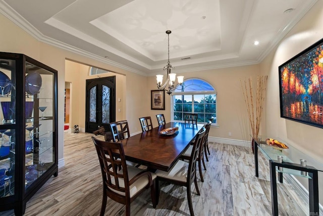 dining space with french doors, a raised ceiling, wood finished floors, a chandelier, and baseboards