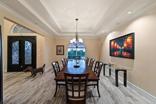 dining room featuring french doors, a notable chandelier, a raised ceiling, wood finished floors, and baseboards