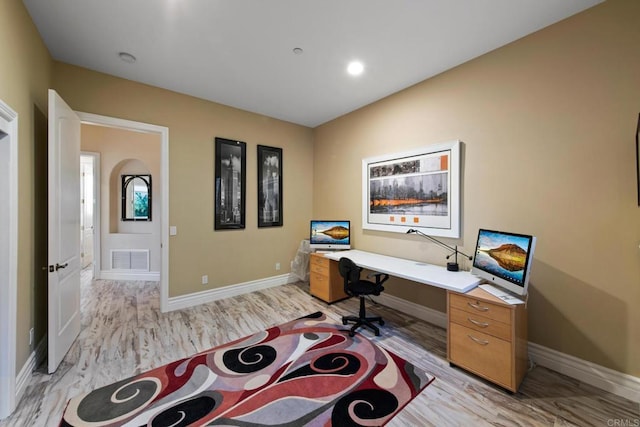 office featuring baseboards, visible vents, and light wood finished floors