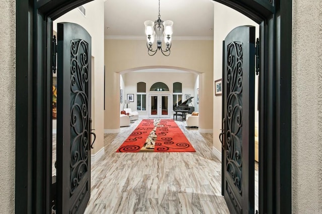 246 Yucca, Fallbrook, CA 92028 - entryway featuring arched walkways, ornamental molding, a chandelier, french doors, and light wood-style floors