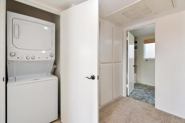 clothes washing area with stacked washer and clothes dryer and light colored carpet