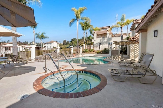 view of swimming pool featuring a hot tub and a patio area