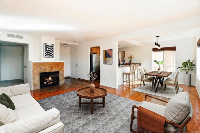 living room with dark hardwood / wood-style floors and a high end fireplace