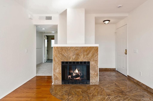 unfurnished living room featuring hardwood / wood-style flooring and a high end fireplace