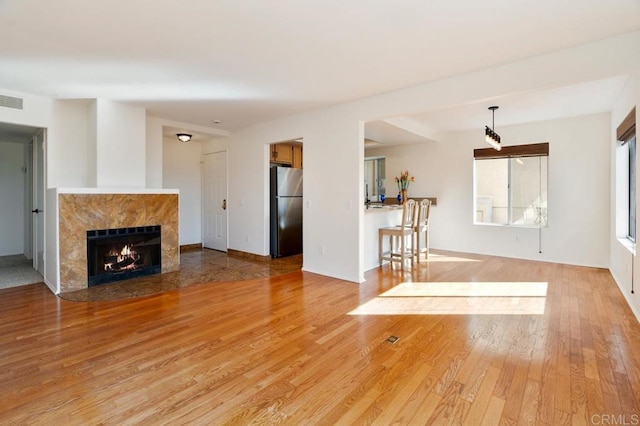 unfurnished living room featuring a fireplace and light hardwood / wood-style flooring