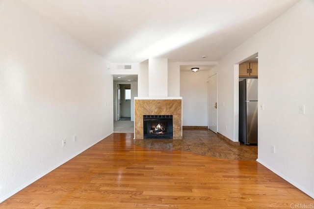 unfurnished living room featuring light hardwood / wood-style flooring and a premium fireplace