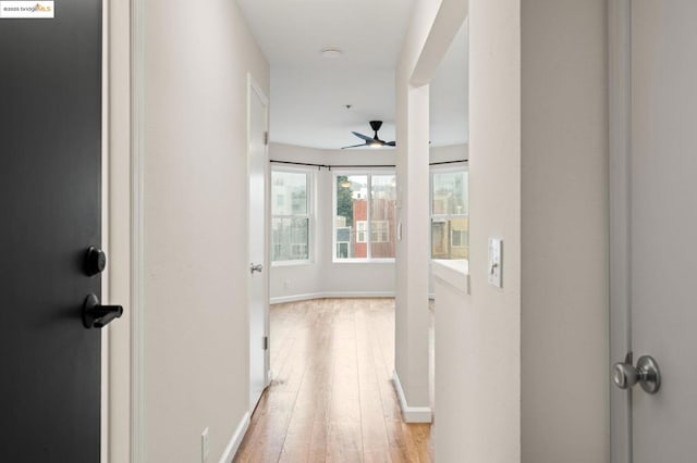 hallway with light hardwood / wood-style floors