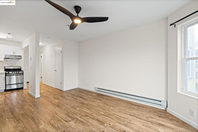 unfurnished living room with ceiling fan, light hardwood / wood-style flooring, and a baseboard radiator