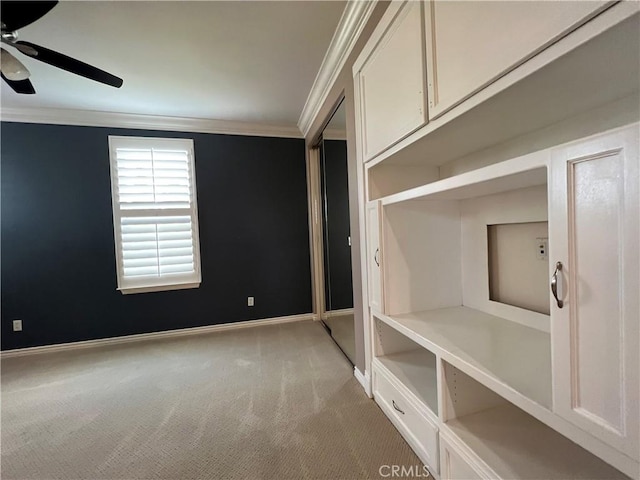 interior space with a closet, carpet, crown molding, and ceiling fan