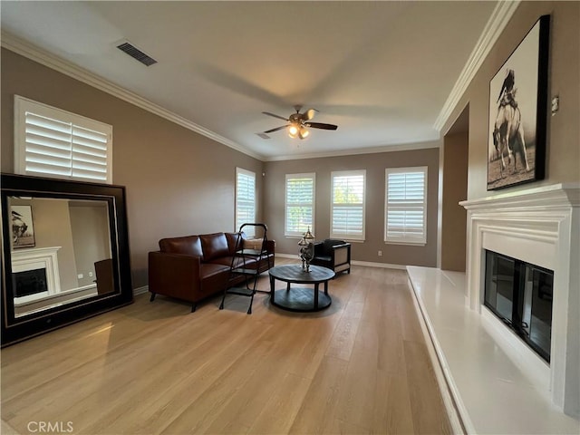 living room with ceiling fan, light hardwood / wood-style flooring, and crown molding