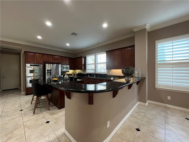 kitchen featuring light tile patterned flooring, appliances with stainless steel finishes, a kitchen bar, and sink