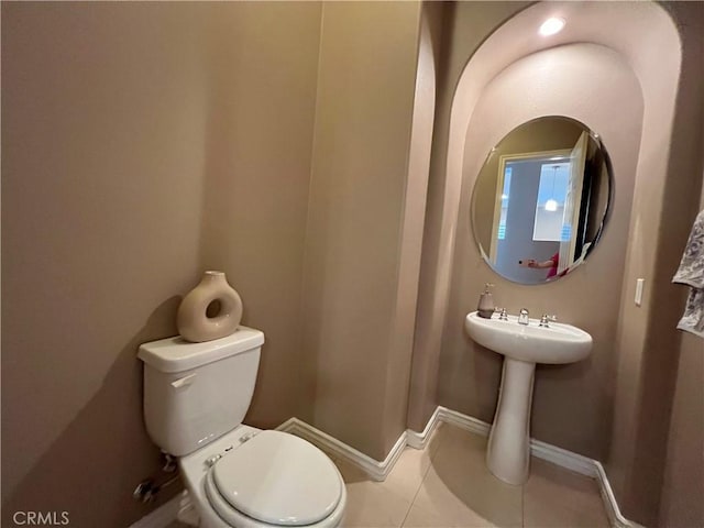 bathroom with toilet and tile patterned flooring