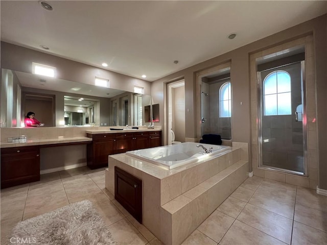 bathroom with tile patterned flooring, separate shower and tub, and vanity