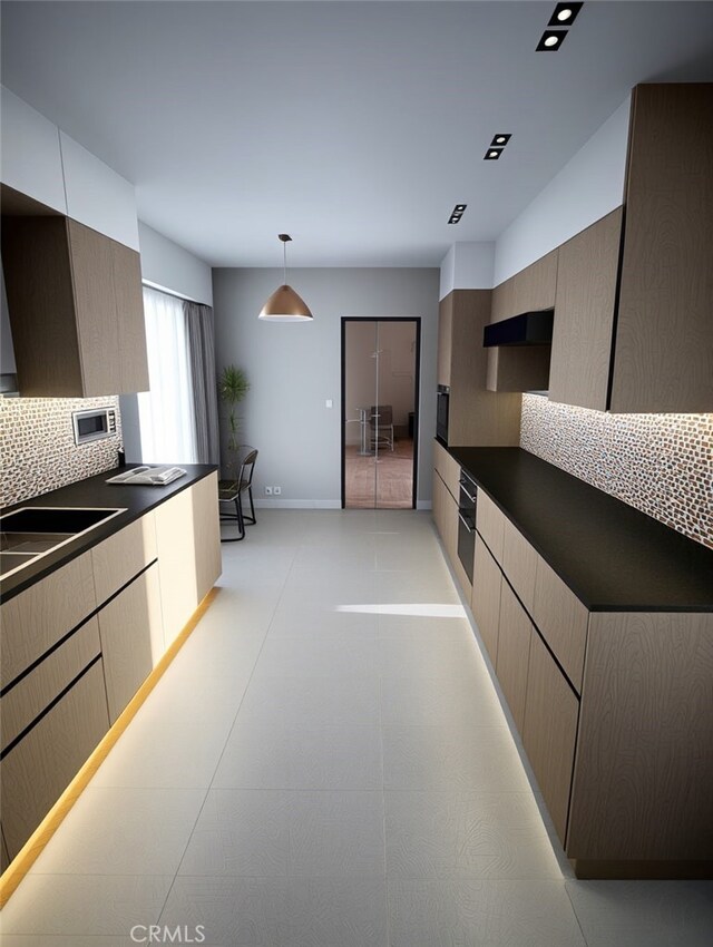 kitchen featuring decorative light fixtures, sink, backsplash, and oven