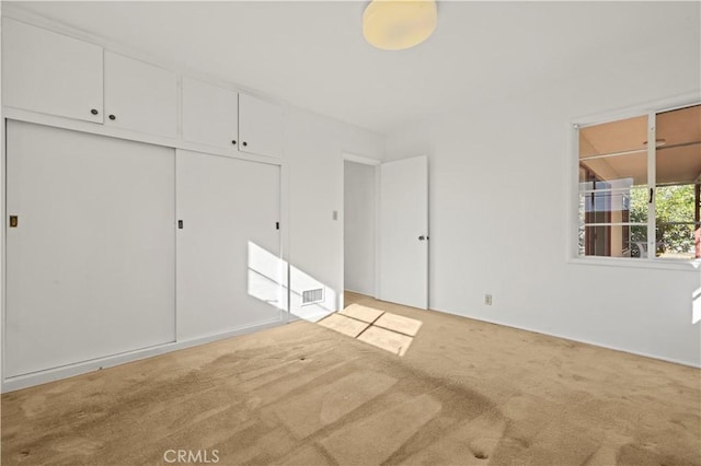 unfurnished bedroom with a closet and carpet floors