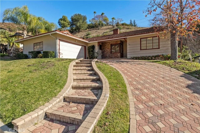 ranch-style house featuring a front lawn and a garage