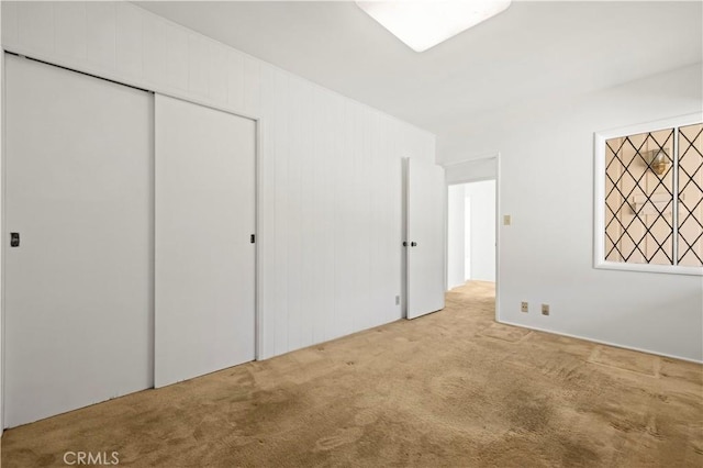 unfurnished bedroom with a closet and light carpet