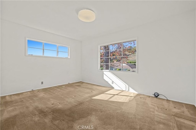 carpeted spare room featuring plenty of natural light