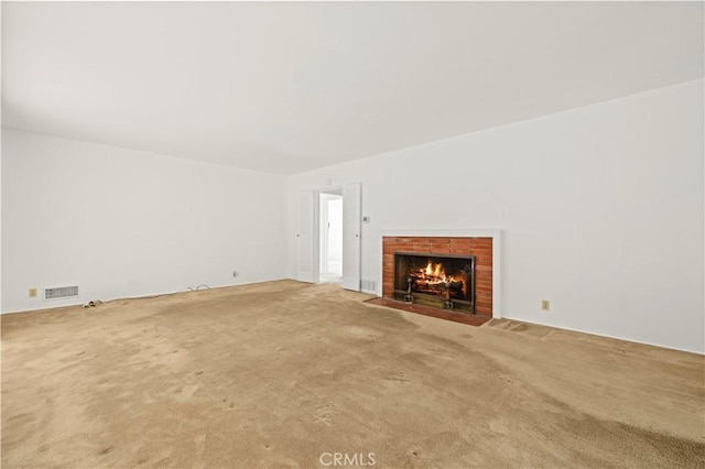 unfurnished living room featuring carpet flooring and a fireplace