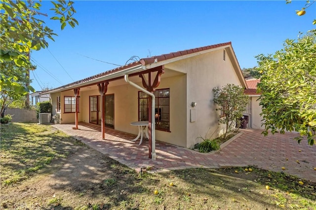 back of property featuring central air condition unit and a patio