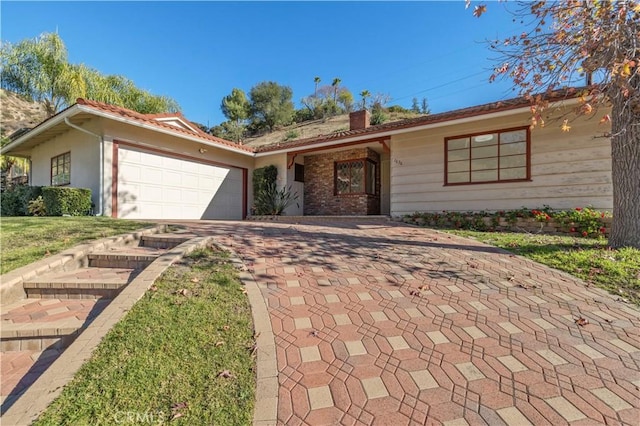 single story home featuring a garage and a front yard