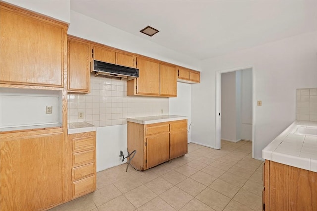 kitchen featuring tile counters, light tile patterned floors, and decorative backsplash