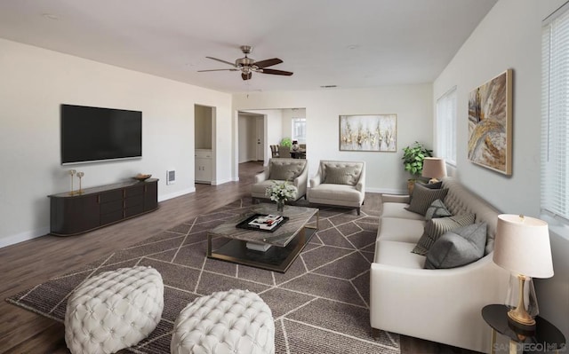 living room featuring ceiling fan and dark wood-type flooring