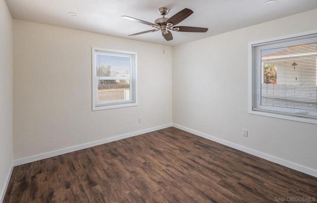 empty room with dark wood-type flooring, a healthy amount of sunlight, and ceiling fan