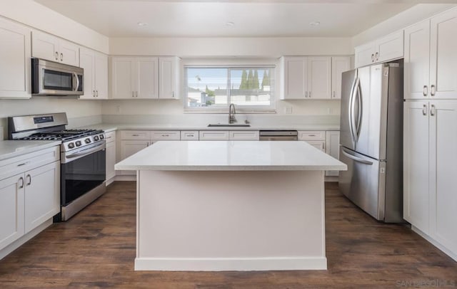 kitchen with a center island, sink, stainless steel appliances, and white cabinetry