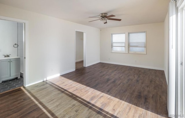 unfurnished bedroom with dark wood-type flooring, ceiling fan, and ensuite bath