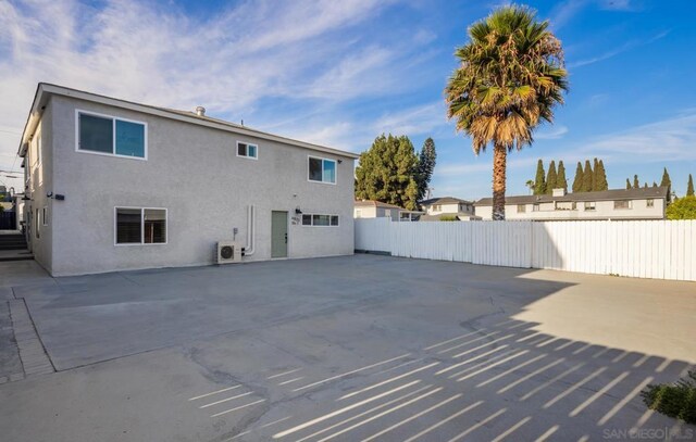 rear view of property featuring a patio area and ac unit