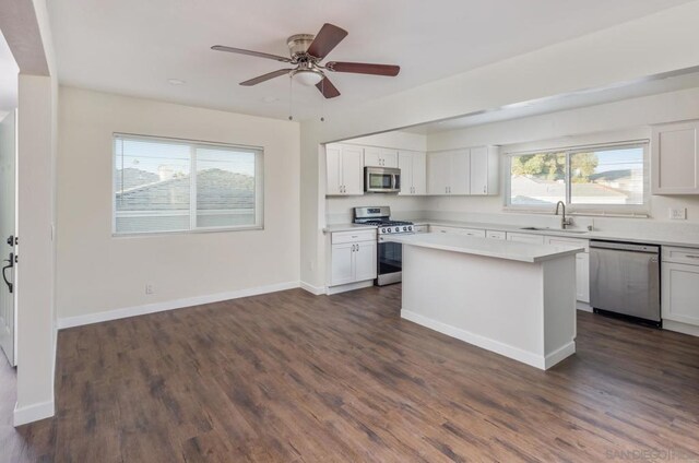 kitchen with sink, white cabinets, stainless steel appliances, and a kitchen island