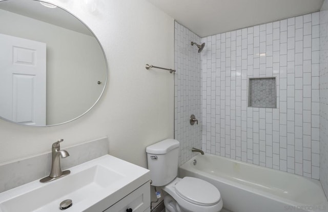 full bathroom featuring toilet, tiled shower / bath, and vanity