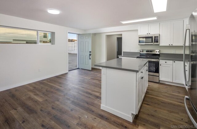 kitchen with a center island, dark wood-type flooring, stainless steel appliances, and white cabinetry