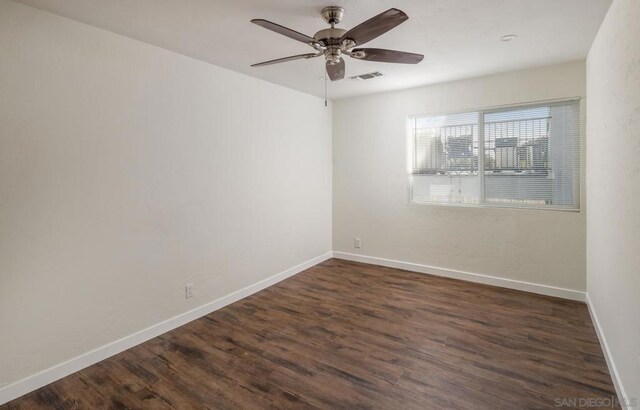 empty room featuring ceiling fan and dark hardwood / wood-style flooring