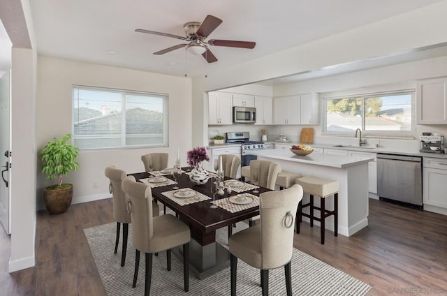 dining space featuring ceiling fan, dark wood-type flooring, sink, and plenty of natural light