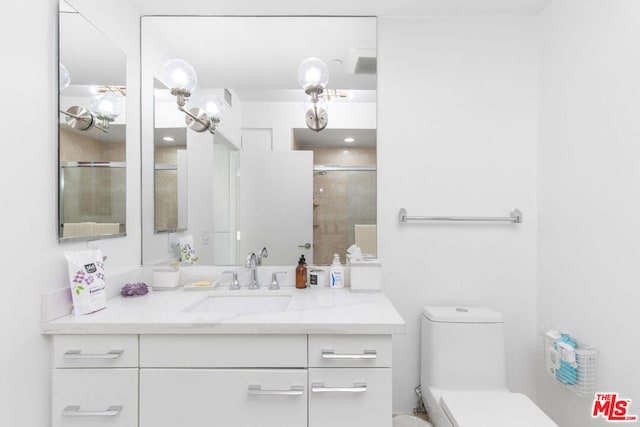 bathroom featuring toilet, vanity, and walk in shower