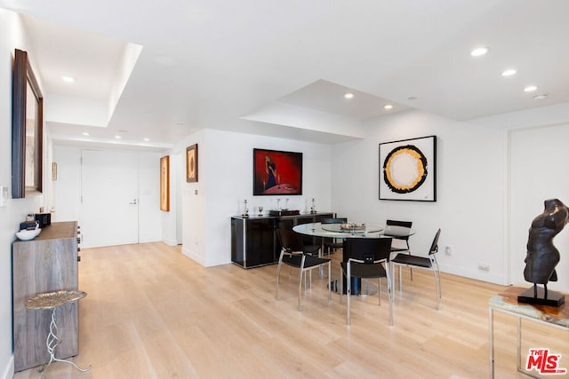 dining room featuring indoor bar and light wood-type flooring