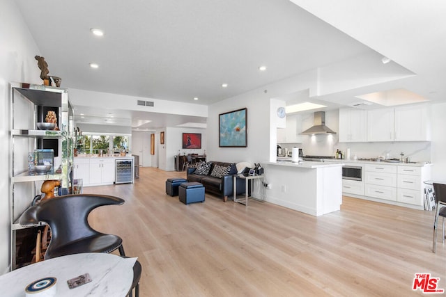 living room featuring beverage cooler and light hardwood / wood-style flooring