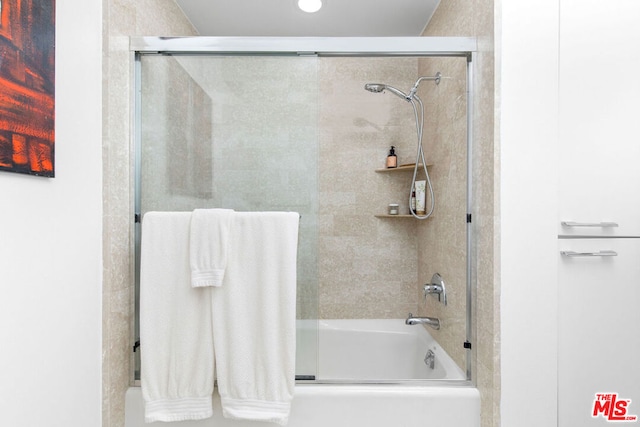 bathroom with shower / bath combination with glass door