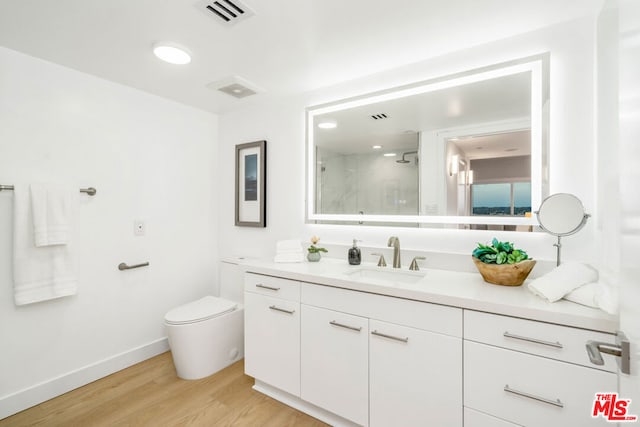 bathroom featuring hardwood / wood-style floors, toilet, vanity, and an enclosed shower