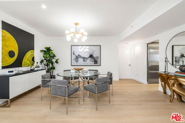 dining area featuring light wood-type flooring and a chandelier