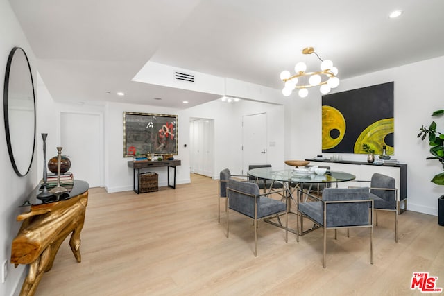 dining area featuring light hardwood / wood-style flooring and a chandelier