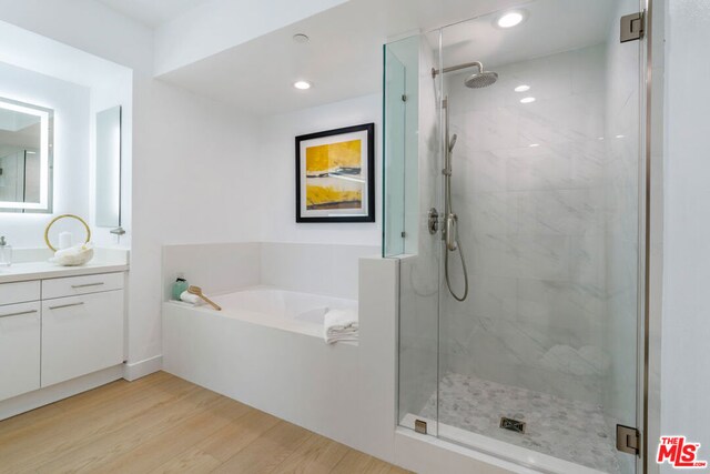 bathroom with vanity, wood-type flooring, and independent shower and bath